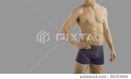 Naked torso of handsome sexy man model in underwear isolated on grey studio background. Toned muscular male in underclothing garment wear advertise briefs. Fashion and style. Copy space. 86283666