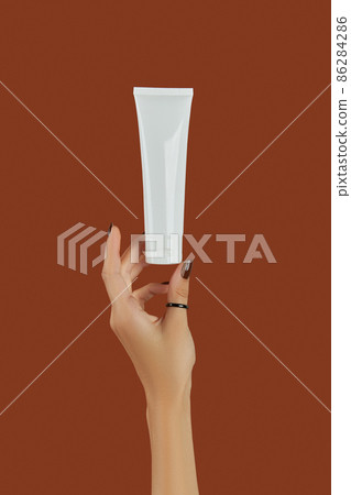 Womans hand with cosmetic cream or cleanser on brown background 86284286