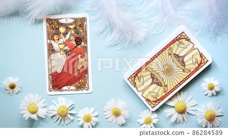Golden tarot cards on the Blue background with Daisy flowers, three of cups Golden tarot cards on the Blue background with Daisy flowers, three of cups 86284589