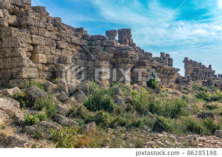 ruins of ancient city walls against the backdrop of the sky with moon in Side, Turkey 86285198
