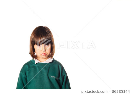 Cute angry little five years old girl with a negativity expression and a juniors school uniform. she is angry about going back to school. isolated white background 86285344