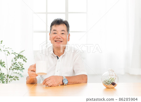 Elderly man drinking a drink in a mug 86285904