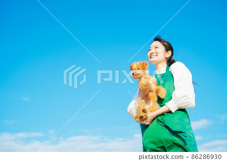 A woman who plays with a dog 86286930