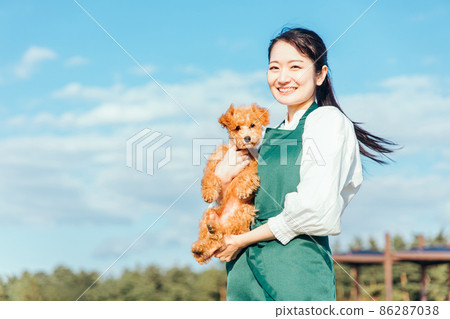 Female playing with her dog (looking at the camera) 86287038