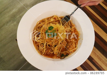 Spaghetti with tomato sauce on white plate with fork beside Spaghetti with tomato sauce on white plate with fork beside 86289785