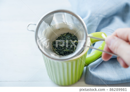 綠茶放入帶有濾茶器的杯子中 86289981
