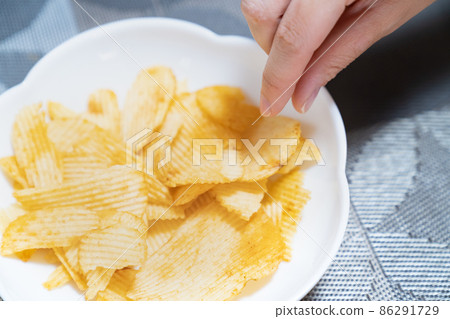 一張試圖吃美味薯片的地方的照片。看起來很胖的糖果的形象。 86291729