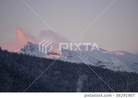 Meakan-dake dyed red in the morning sun seen from Lake Akan in winter 86291907