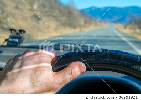 driver hand on the steering wheel inside the car driver hand on the steering wheel inside the car 86291921