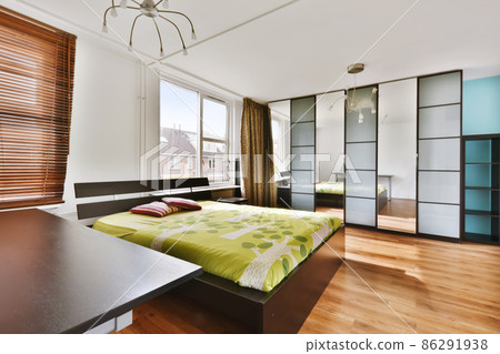 A fascinating bedroom with a bed covered with a green bedspread and two chandeliers A fascinating bedroom with a bed covered with a green bedspread and two chandeliers 86291938
