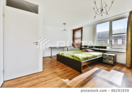 A fascinating bedroom with a bed covered with a green bedspread and two chandeliers A fascinating bedroom with a bed covered with a green bedspread and two chandeliers 86291939