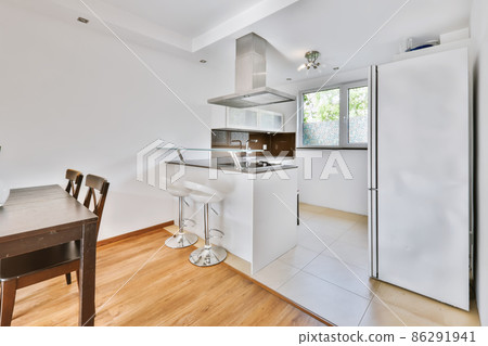 A fascinating kitchen with a mirrored black countertop and beige tiled floor A fascinating kitchen with a mirrored black countertop and beige tiled floor 86291941