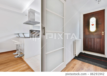 The entrance part of the house with a wooden door and a radiator nearby 86291942
