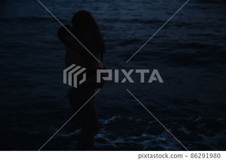 girl and boyfriend love each other, hug and kiss standing in water in sea by beach on a summer night girl and boyfriend love each other, hug and kiss standing in water in sea by beach on a summer night 86291980