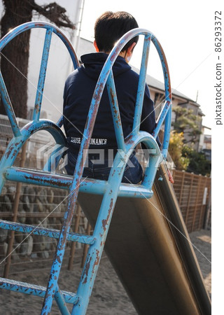 A boy playing on a slide 86293372