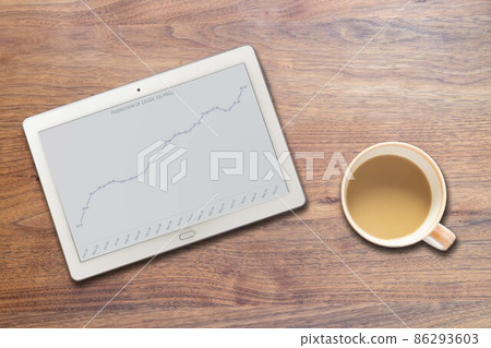 Tablets and coffee cups showing the rise in oil prices Tablets and coffee cups showing the rise in oil prices 86293603