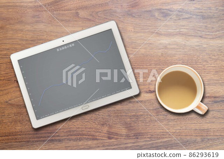 Tablet terminals and coffee cups that show changes in crude oil prices 86293619