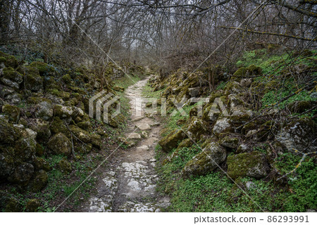 Trail with old stone ruins in the rock Cave city Chufut-Kale in Bakhchysarai, Crimea Trail with old stone ruins in the rock Cave city Chufut-Kale in Bakhchysarai, Crimea 86293991