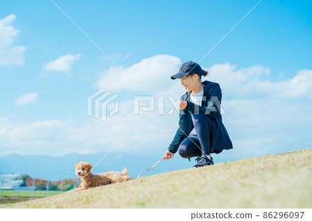 穿著運動服遛狗的女人（全身） 86296097