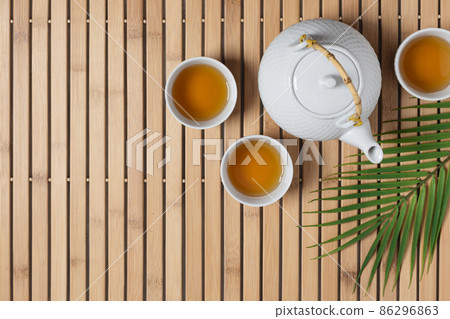 White teapot and tea cups with tea drink top view. 86296863