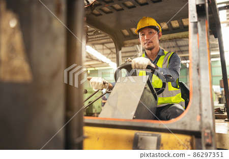 Engineer Man forklift driver with a background in an industrial or warehousing factory. Engineer Man forklift driver with a background in an industrial or warehousing factory. 86297351