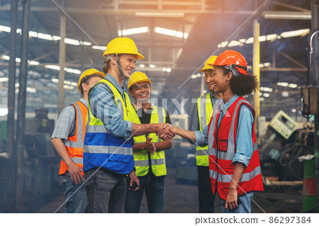 A group of industry workers and engineers of various races enjoy working in a heavy plant and stand together with a pleasant smile. portrait A group of industry workers and engineers of various races enjoy working in a heavy plant and stand together with a pleasant smile. portrait 86297384