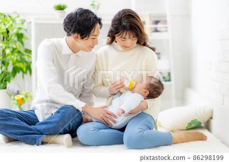 A couple giving milk to their baby 86298199