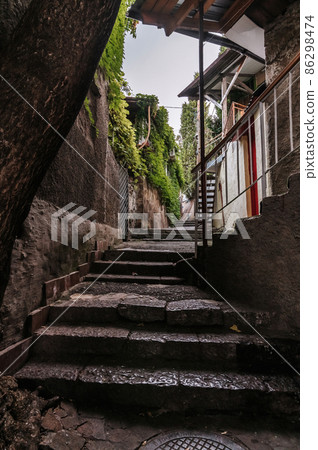 beautiful narrow alley with stone trim and facades of buildings 86298474