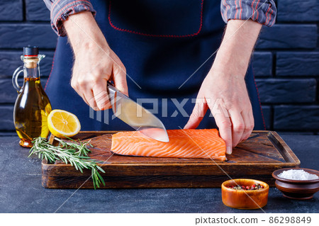 Man is cutting salmon fillet., top view Man is cutting salmon fillet., top view 86298849