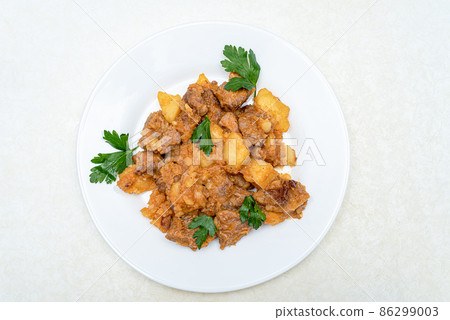 Top view of roast pork, parsley potatoes in a white plate. Top view of roast pork, parsley potatoes in a white plate. 86299003