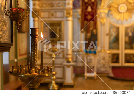 Orthodox Church. Christianity. Festive interior decoration with burning candles and icon in traditional Orthodox Church on Easter Eve or Christmas. Religion faith pray symbol Orthodox Church. Christianity. Festive interior decoration with burning candles and icon in traditional Orthodox Church on Easter Eve or Christmas. Religion faith pray symbol 86300075