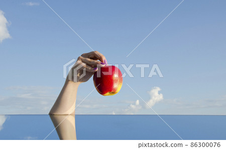 girl hand holding red apple and sky girl hand holding red apple and sky 86300076