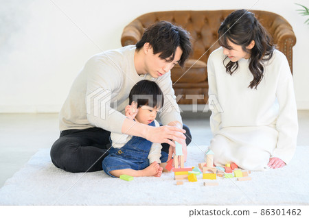 A young family playing with a baby in a beautiful new-built room with a beautiful mom and family 86301462