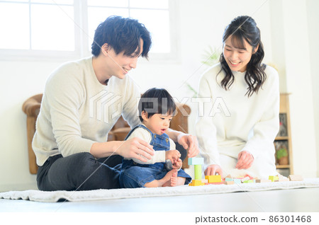 A young family playing with a baby in a family with a beautiful mom who is pleased with the growth of the child A young family playing with a baby in a family with a beautiful mom who is pleased with the growth of the child 86301468