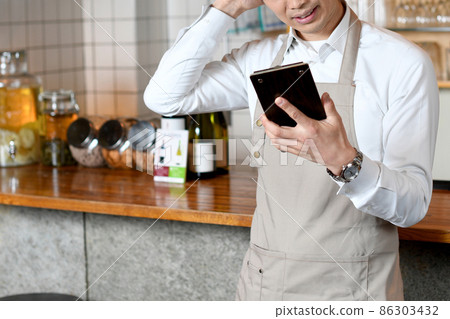 Asian man in an apron worried at a restaurant 86303432
