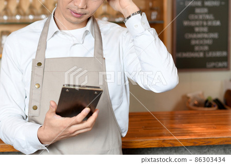 Asian man in an apron worried at a restaurant 86303434
