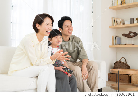一家三口父母和孩子在電視上看體育節目 86303901
