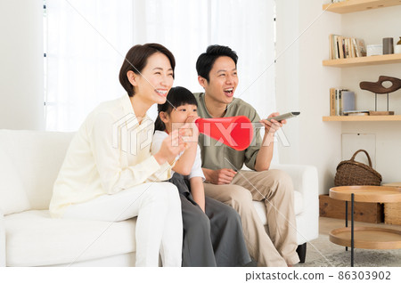 A family of three parents and children watching sports on TV 86303902