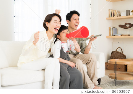 A family of three parents and children watching sports on TV A family of three parents and children watching sports on TV 86303907