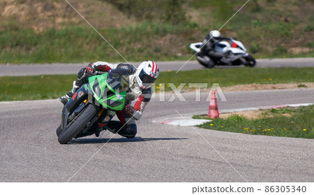 25-05-2020 Riga, Latvia. Motorcyclist goes on road, side view, closeup 25-05-2020 Riga, Latvia. Motorcyclist goes on road, side view, closeup 86305340