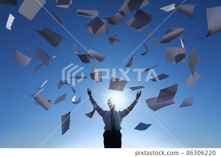 Silhouette of a man throwing documents into the sky 86306220