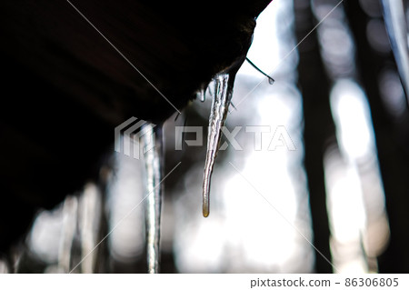 Several icicles on the roof in winter. Selective focus 86306805