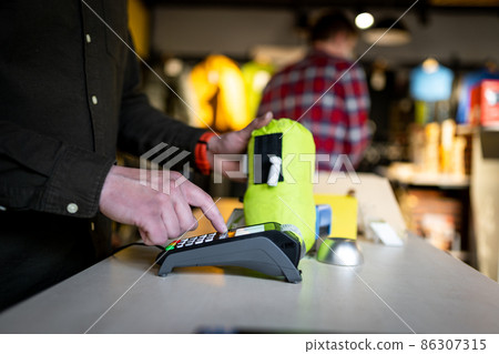 Salesman holds payment terminal while holding receipt for completing purchase. Hands close up. Concept of NFC, business and banking transactions. Payment terminal with paper tape. Bank terminal 86307315