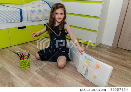 Little girl draws with pencils on the floor in her room. Little girl draws with pencils on the floor in her room. 86307564