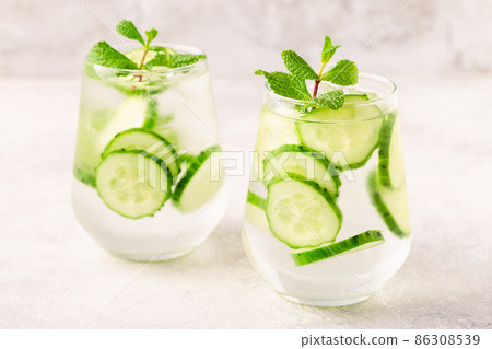 Fresh infused cucumber water on a light background Fresh infused cucumber water on a light background 86308539