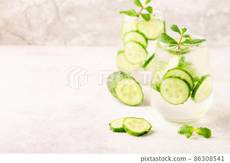 Fresh infused cucumber water on a light background Fresh infused cucumber water on a light background 86308541