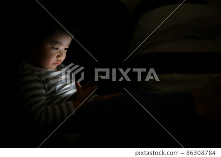 Boy using a smartphone in the dark 86308784