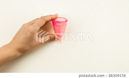Woman hand holding a pink menstrual cup Woman hand holding a pink menstrual cup 86309156