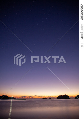 Matsushima and Kuroshima on Torihata Island when the sun rises in the starry sky of Nangocho Nienami Beach in the Pacific Ocean and is dyed in twilight. 86309562