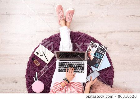 Fashion blogger with laptop sitting on floor, top view Fashion blogger with laptop sitting on floor, top view 86310526
